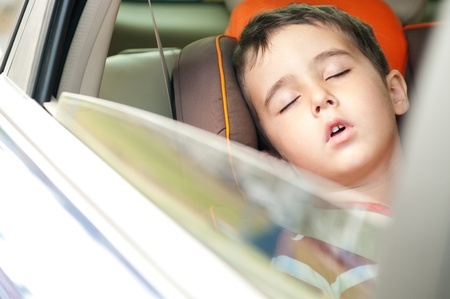 Boy asleep in car.