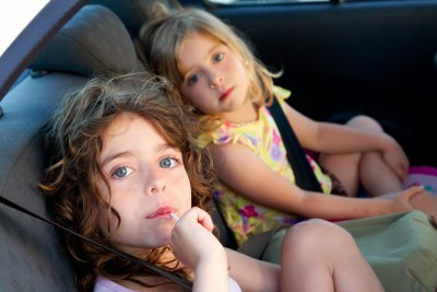Two girls in backseat of car.