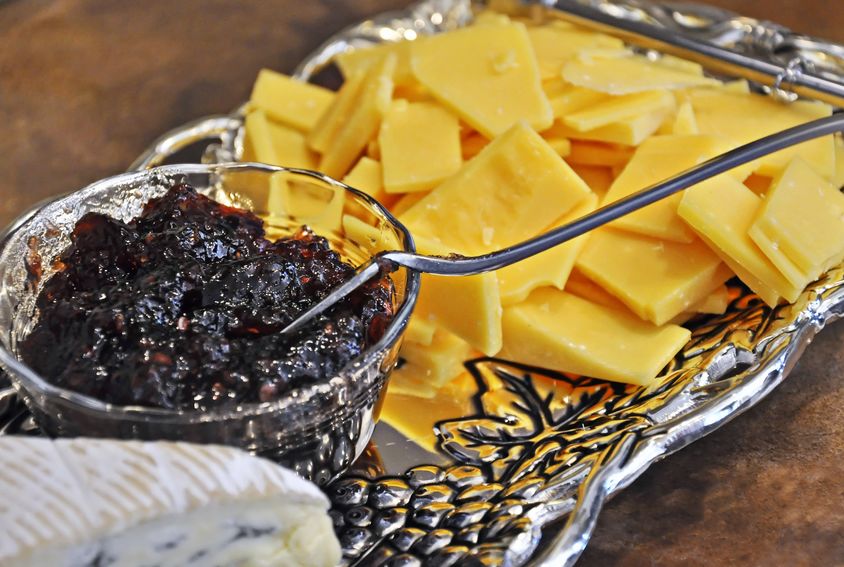 Silver party platter with assortment of cheeses.