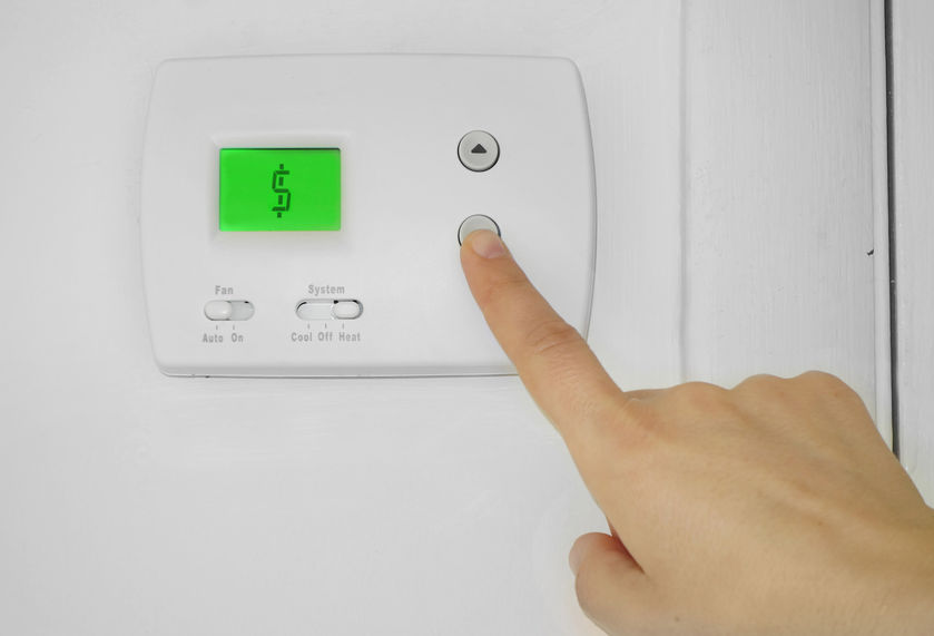 Finger on wall thermostat.