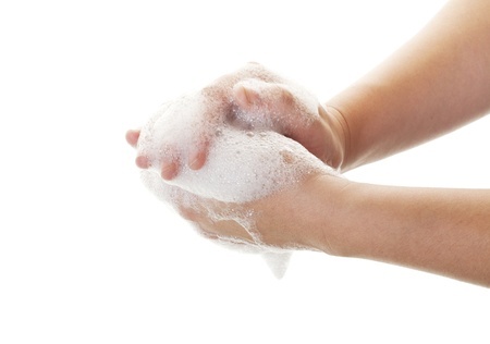 Child washing soapy hands under running water.