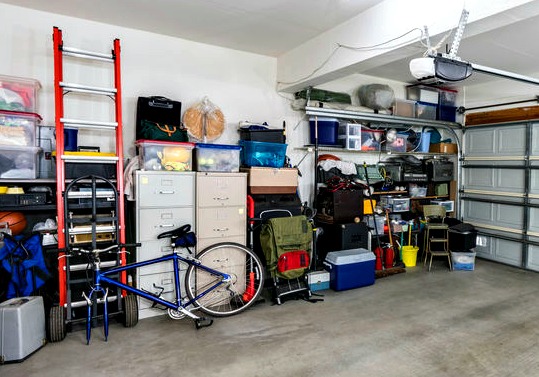 Garage with storage shelves and cabinets.