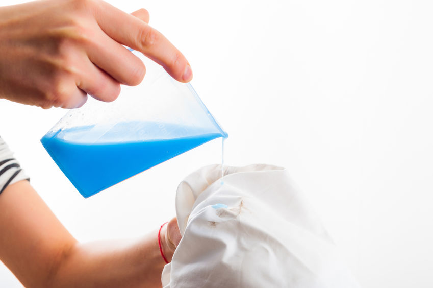 Woman pouring solution on t-shirt stain.
