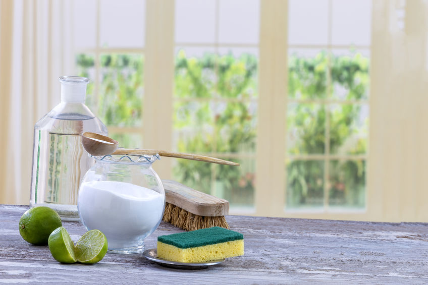 Green cleaning products beside a window.