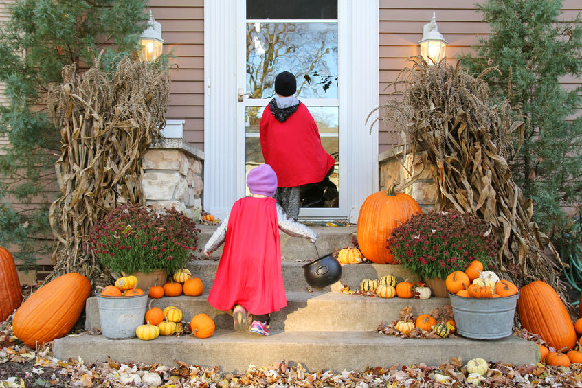 Two costumed kids walking up to home.