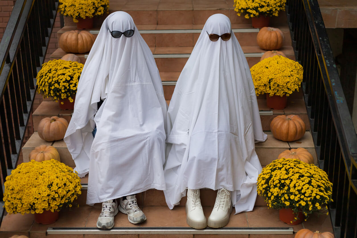 Two kids in Halloween ghost costumes.
