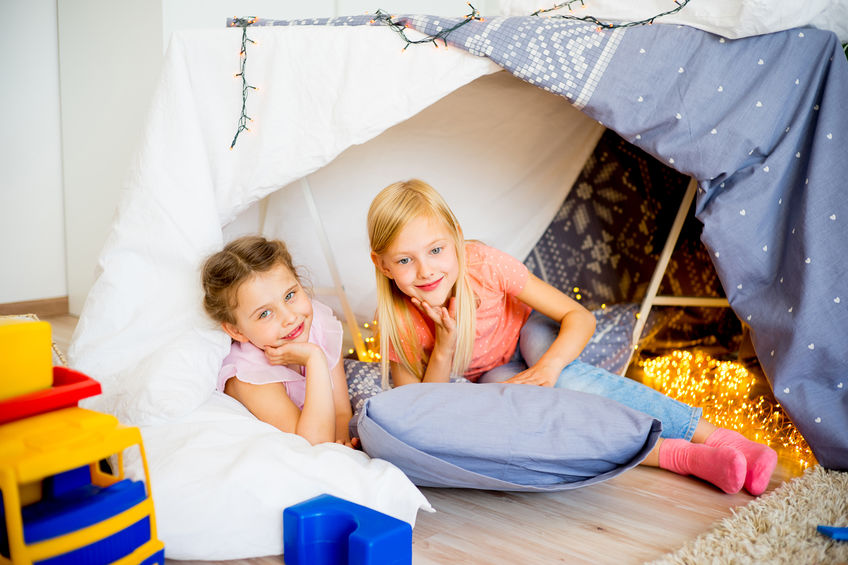 Two girls sitting in bedroom tent.