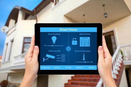 Woman holding a tablet with smart home on screen.