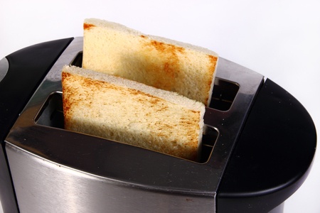 Silver toaster with bread slices inside.