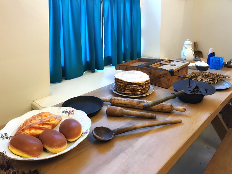 Wood kitchen table and window with blue curtains.