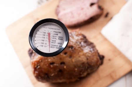 Roast on cutting board with meat thermometer.