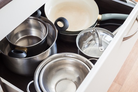 Kitchen drawer with pans organized inside.