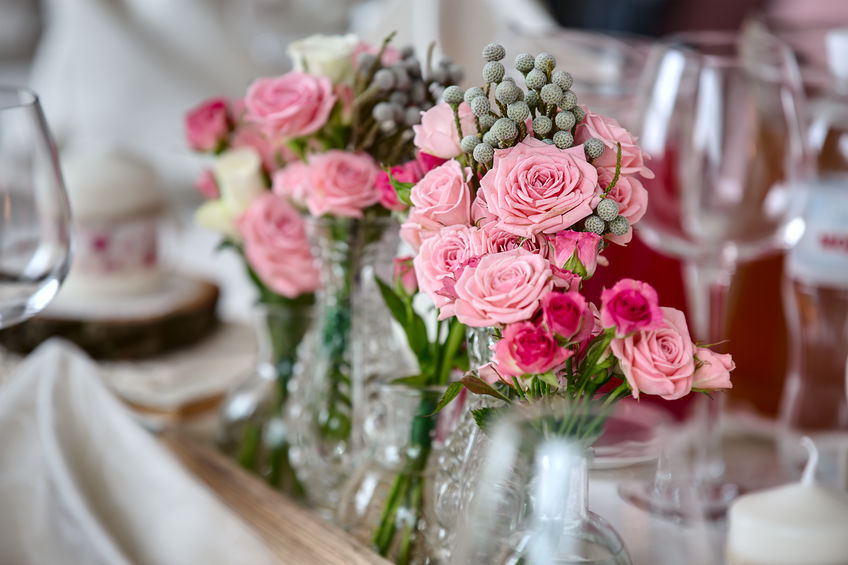 Pink flowers in vase on table.