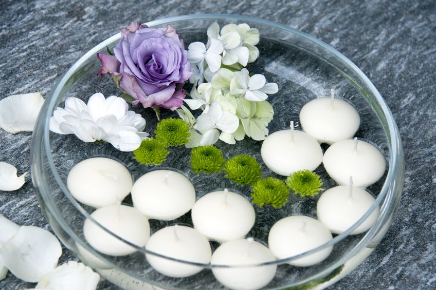 Clear glass bowl with floating white candles.