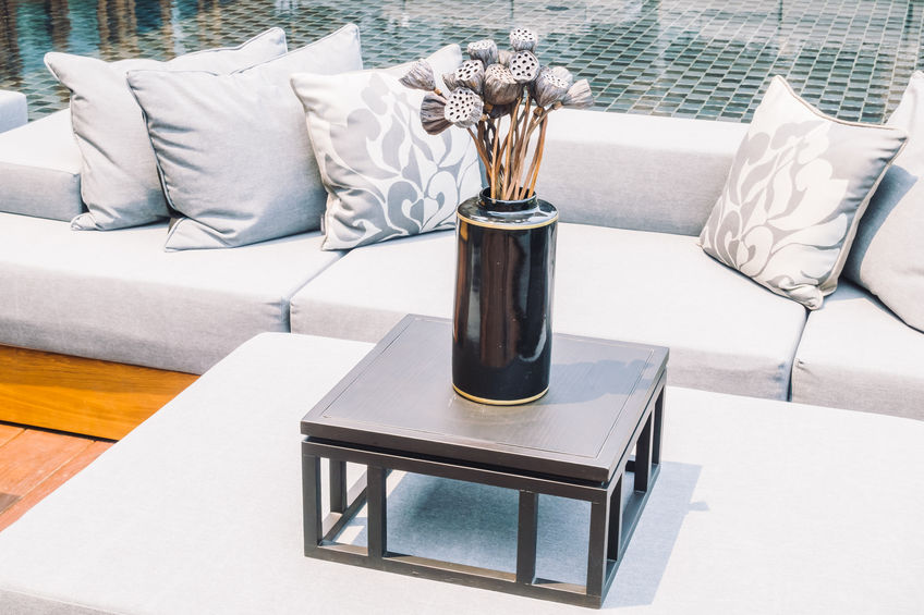 White backyard couch with decorative pillows.