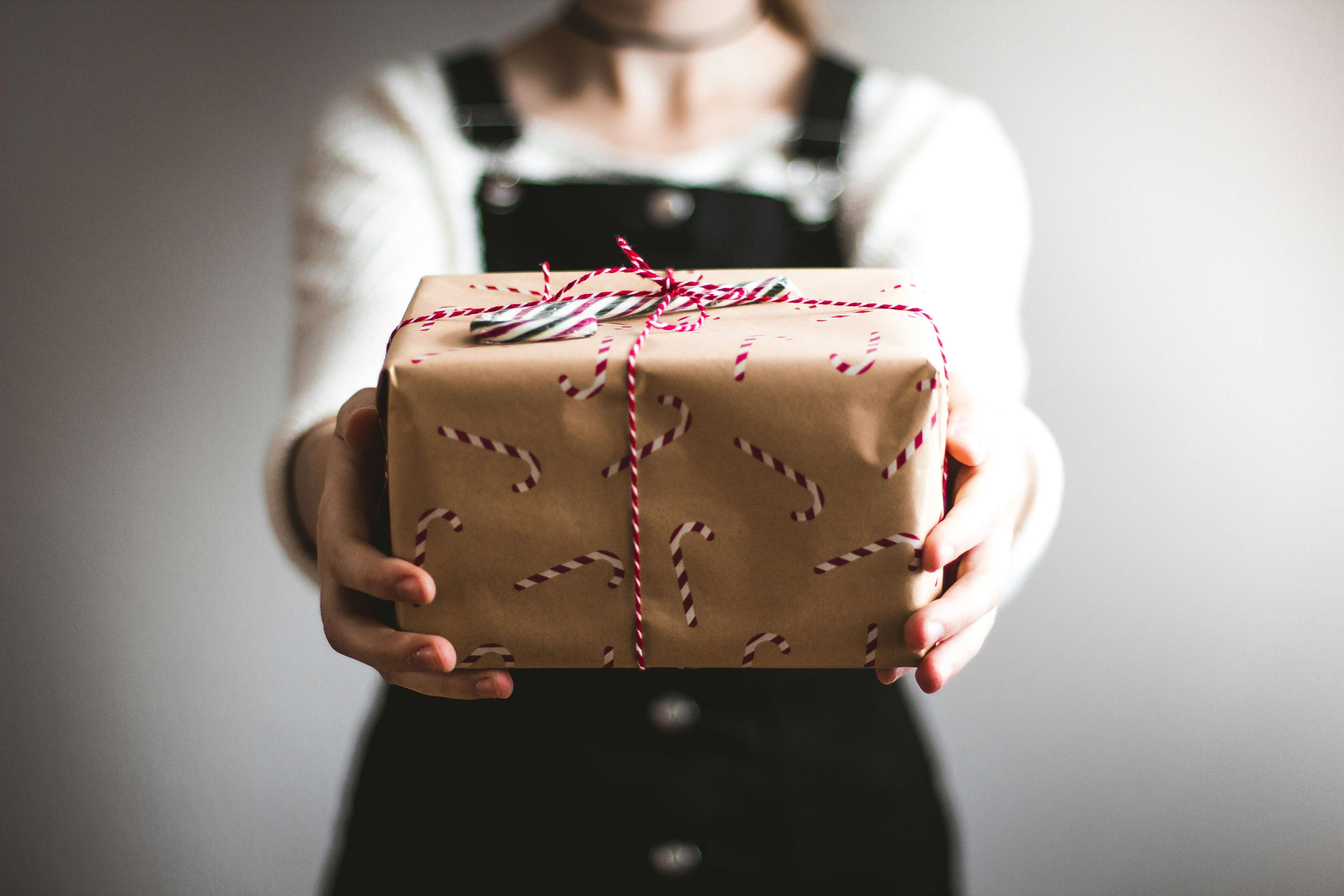 Woman holding out a holiday gift.
