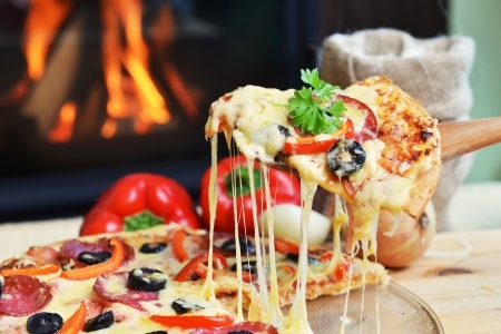 Pizza slice being lifted up.