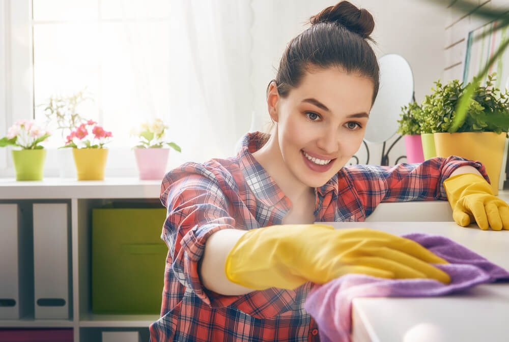 Woman cleaning home table.